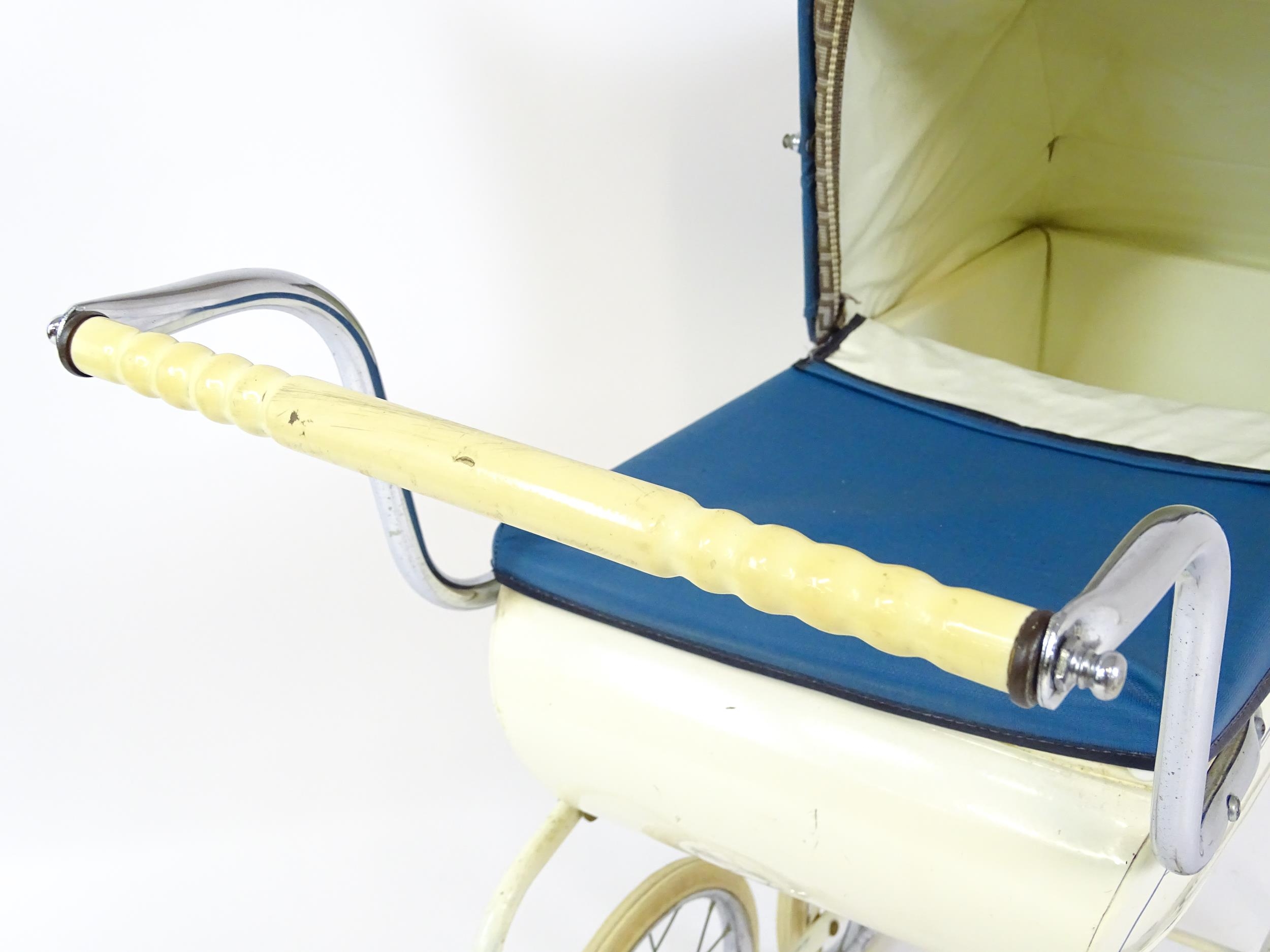 Toys: A 20thC Pedigree dolls pram with cream exterior and blue hood. Together with a plastic doll - Image 11 of 11