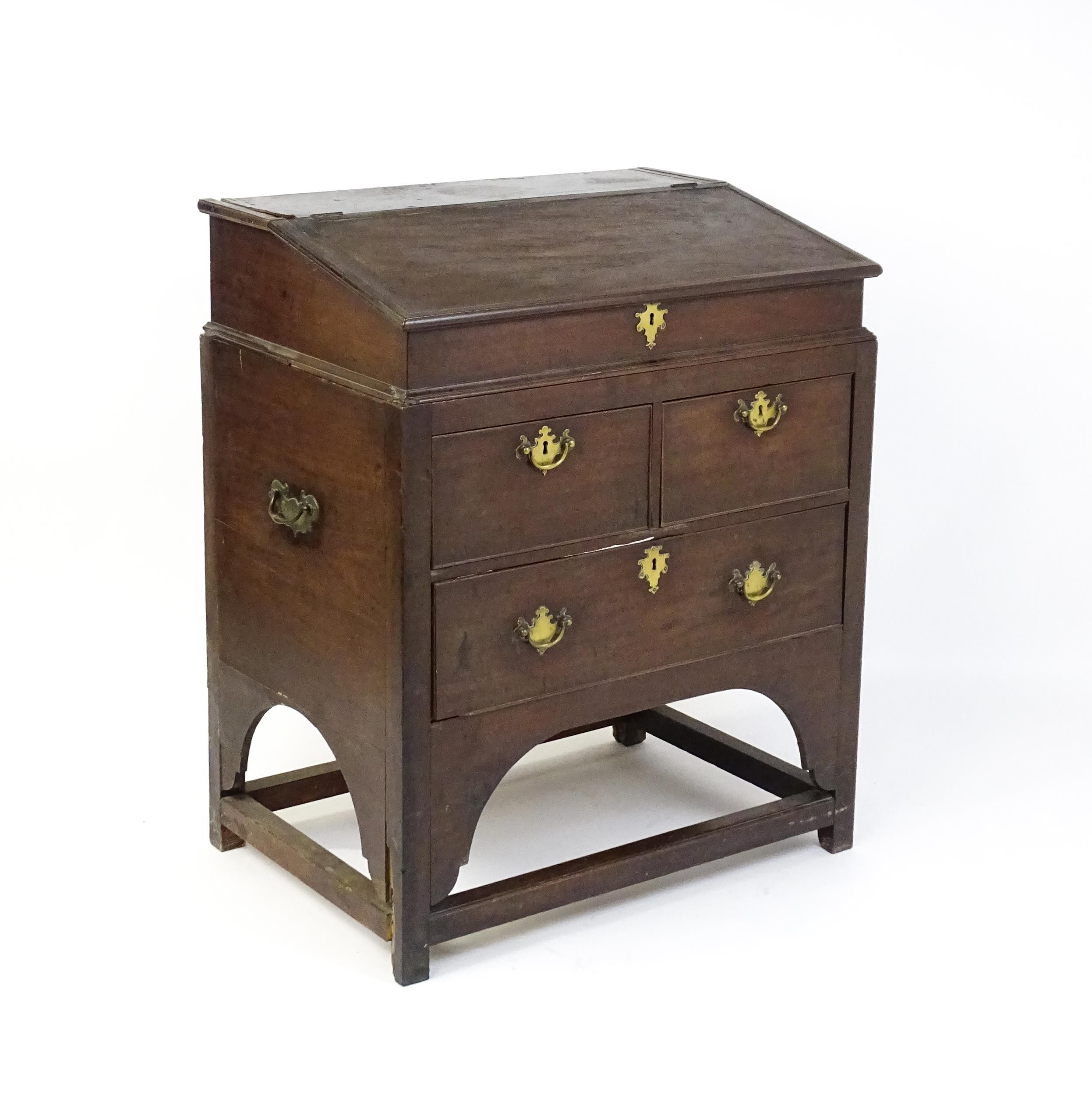 An early / mid 18thC mahogany clerks desk with a hinged sloping lid opening to show a fitted