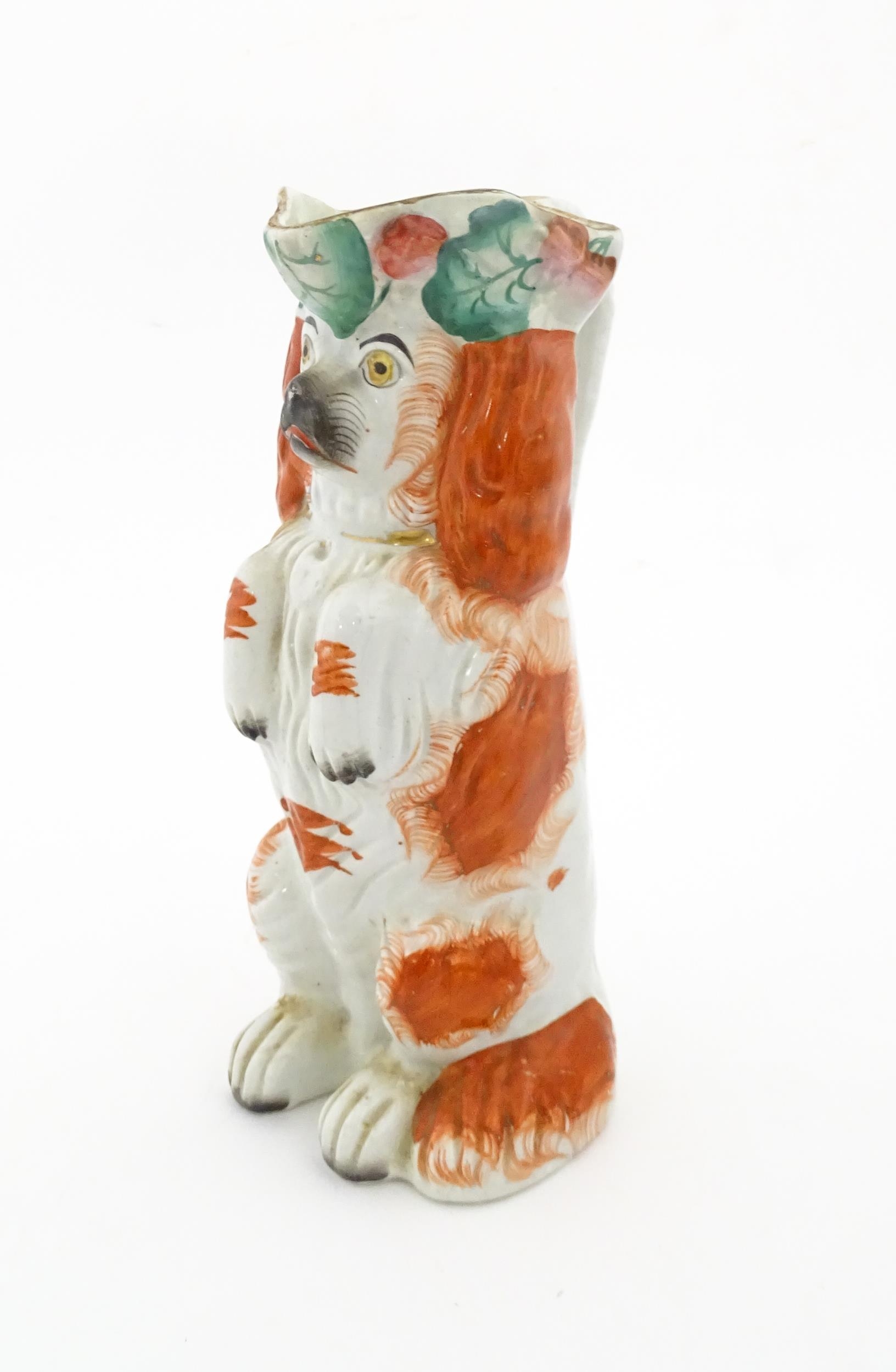 A Victorian Staffordshire jug modelled as a dog wearing a hat with fruiting vine decoration. Approx.