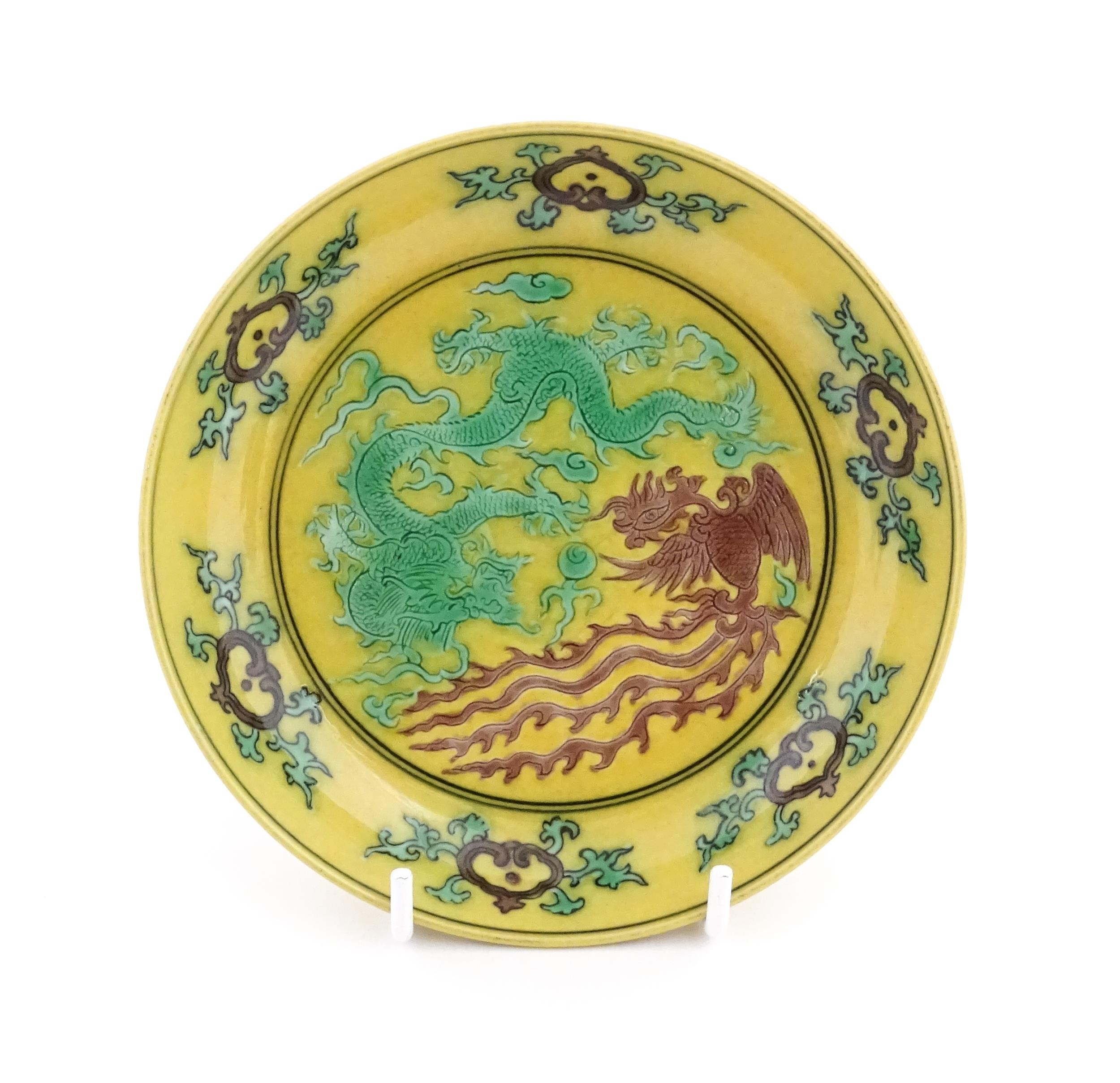 A small Chinese dish with a yellow ground decorated with a dragon, phoenix and flaming pearl. - Image 2 of 3