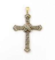 A 9ct gold pendant of cross form with chip set diamonds. Approx. 1 3/4" long Please Note - we do not