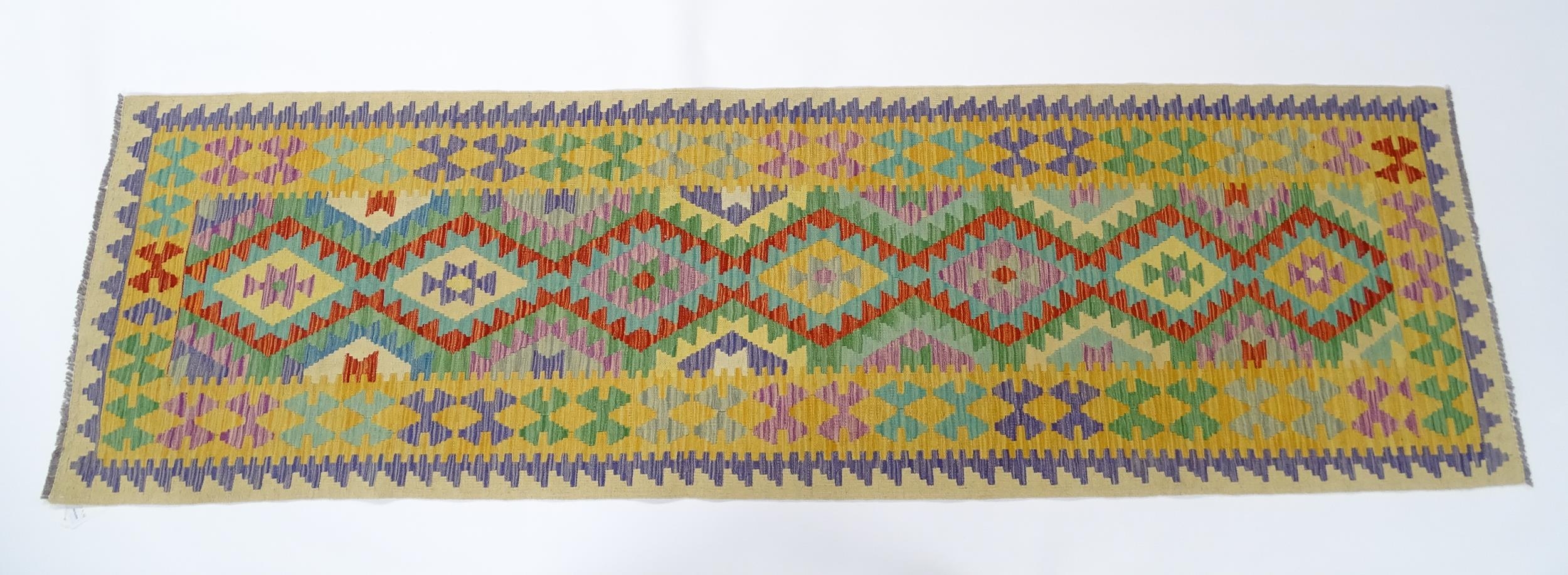 Carpet / Rug : A Turkish Anatolian kilim rug / runner with repeating geometric motifs. Approx. 34" x
