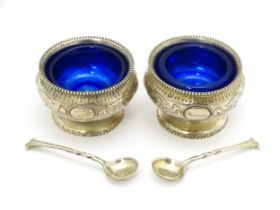 A pair of Victorian silver salts with blue glass liners, hallmarked London 1876, maker John Septimus