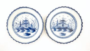 A pair of Liverpool blue and white pearlware plates with feathered edge decorated with a lake