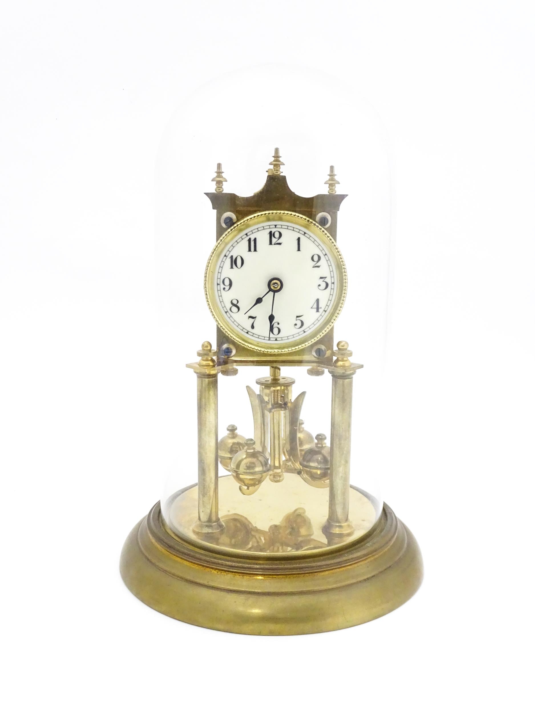 A 20thC anniversary / table clock with white enamel dial and Roman numerals. Under glass dome