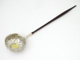 A white metal punch ladle with coin style detail to bowl. Approx 11" long overall Please Note - we