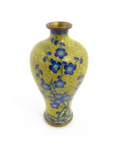 A Chinese cloisonne vase with a yellow ground decorated with blue prunus flowers / blossom.