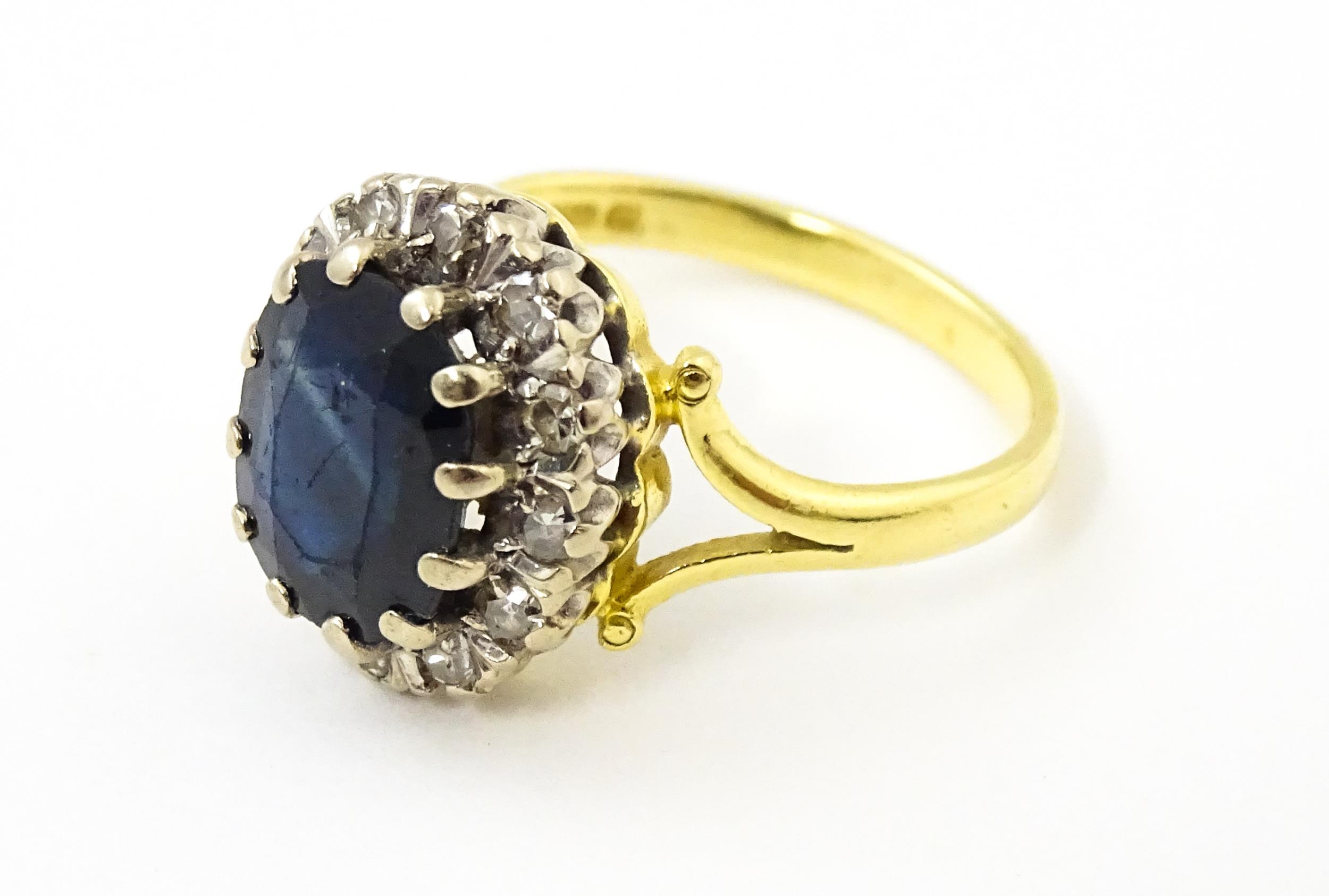 An 18ct gold ring set with central sapphire bordered by diamonds. Ring size approx. L 1/2 Please - Image 5 of 7