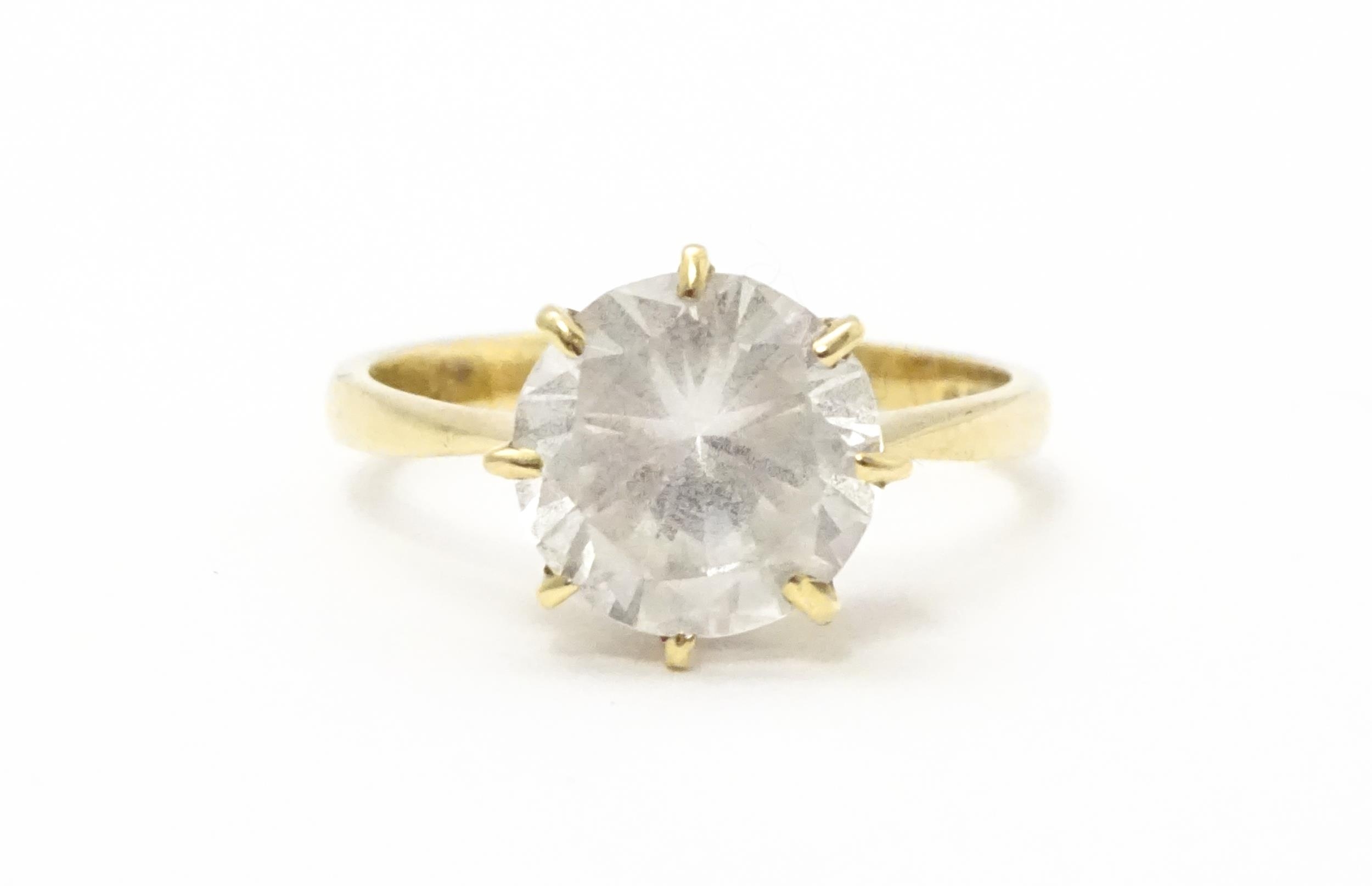 A 9ct gold ring set with a white stone solitaire. Ring size approx. O Please Note - we do not make