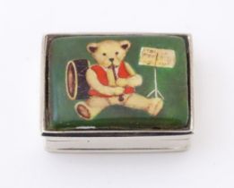 A silver pill box with image of teddy bear to top. Hallmarked London 2002 maker Ari D Norman. Approx