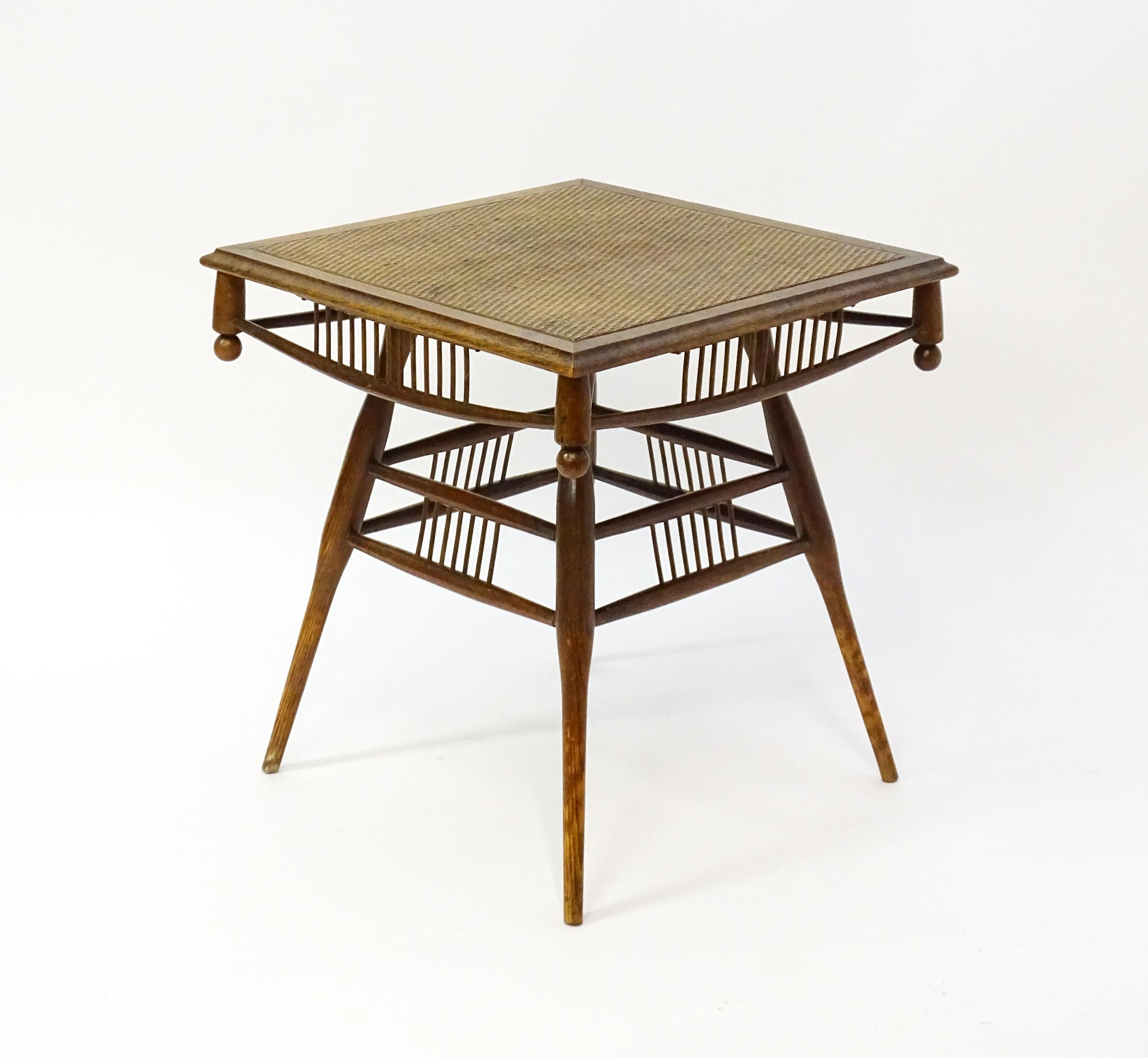 An unusual late 19thC Arts & Crafts table with a rattan inlaid moulded top above three tiers of