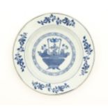 A Chinese blue and white plate depicting a basket of flowers with a foliate border. With blue