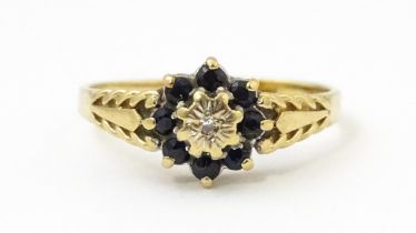 A 9ct gold ring set with central diamond bordered by sapphires. Ring size approx. M Please Note - we