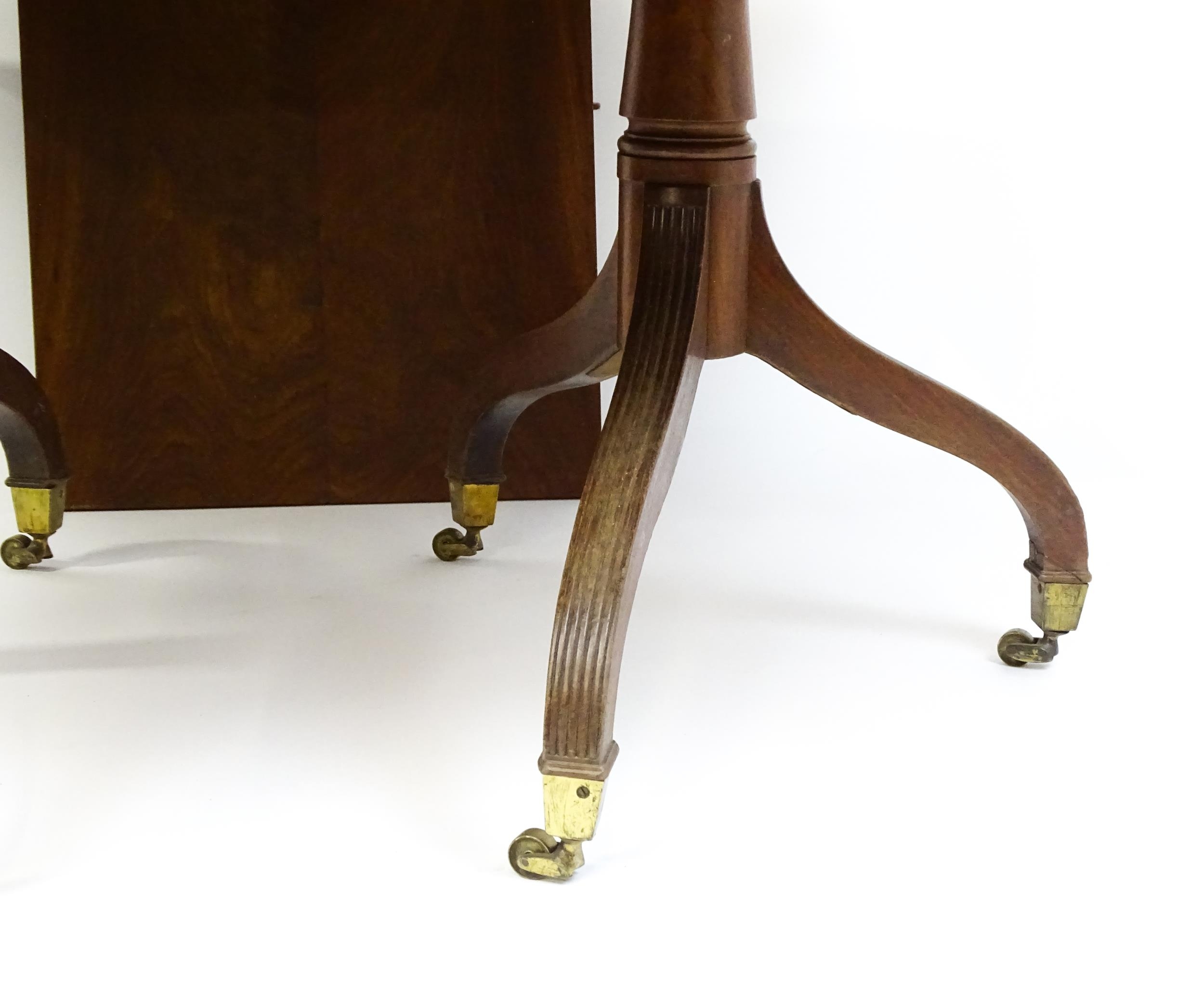 A Georgian mahogany double pedestal dining table raised on reeded legs terminating in brass caps and - Image 4 of 4