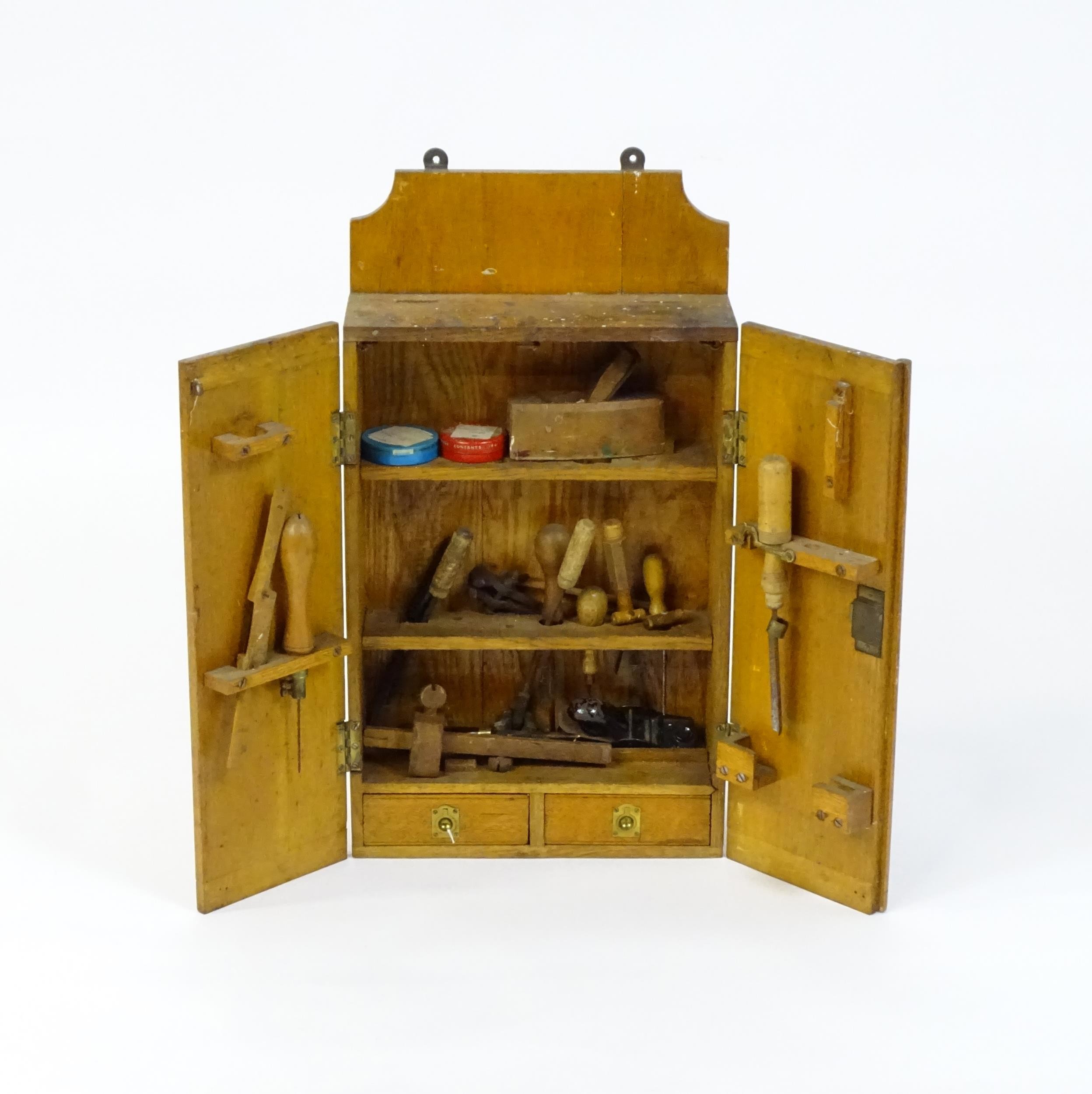 An early / mid 20thC wall hanging work box , containing carpentry / woodworking tools to include