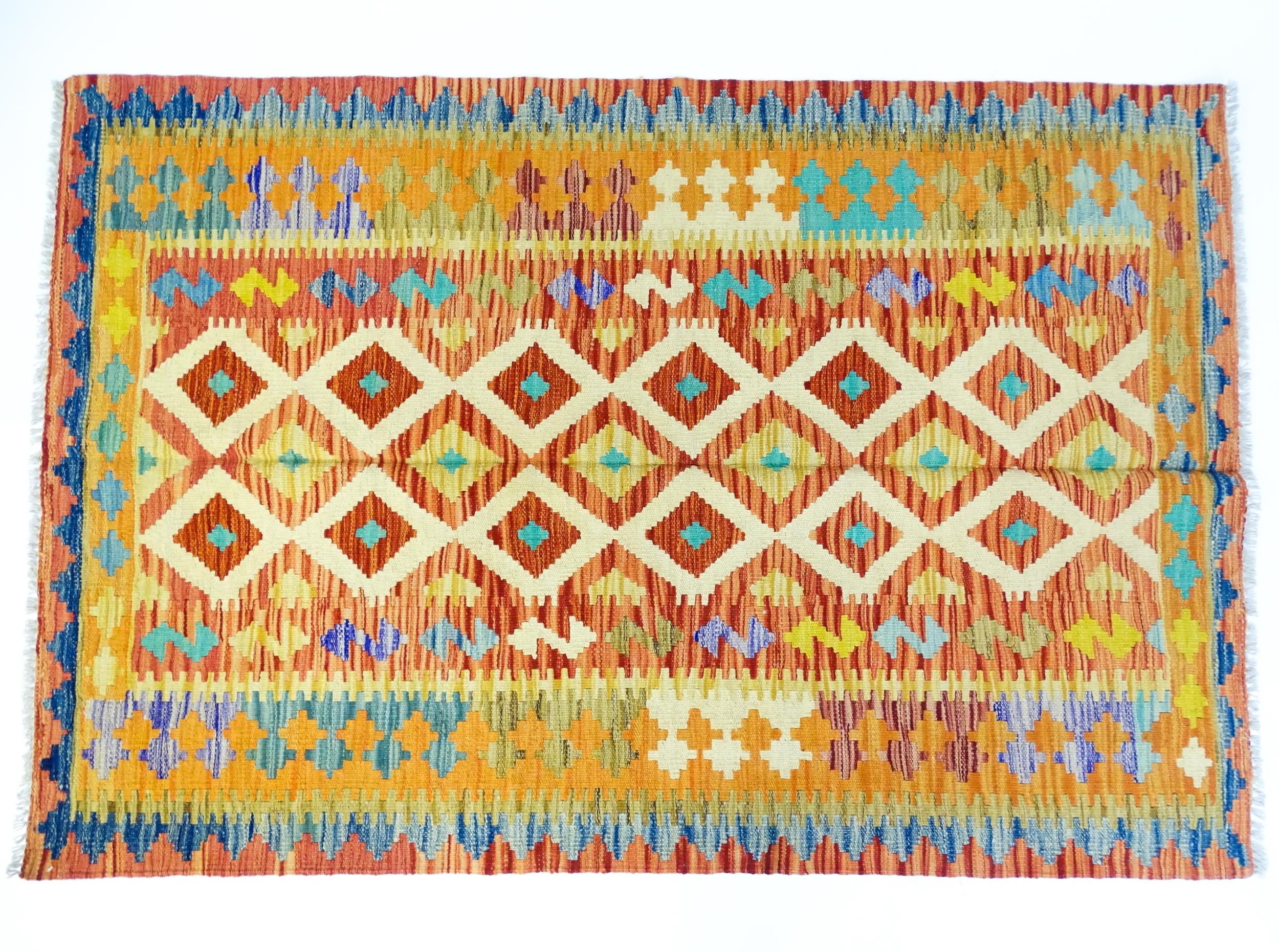 Carpet / Rug : A Turkish Anatolian kilim rug with repeating geometric motifs. Approx. 72" x 48"