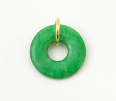 A green jade coloured hardstone pendant with yellow metal mount. Approx 3/4" wide Please Note - we