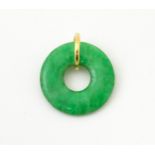 A green jade coloured hardstone pendant with yellow metal mount. Approx 3/4" wide Please Note - we