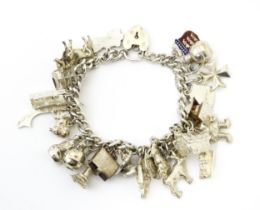 A silver charm bracelet with various silver, white metal and silver plate charms. Please Note - we