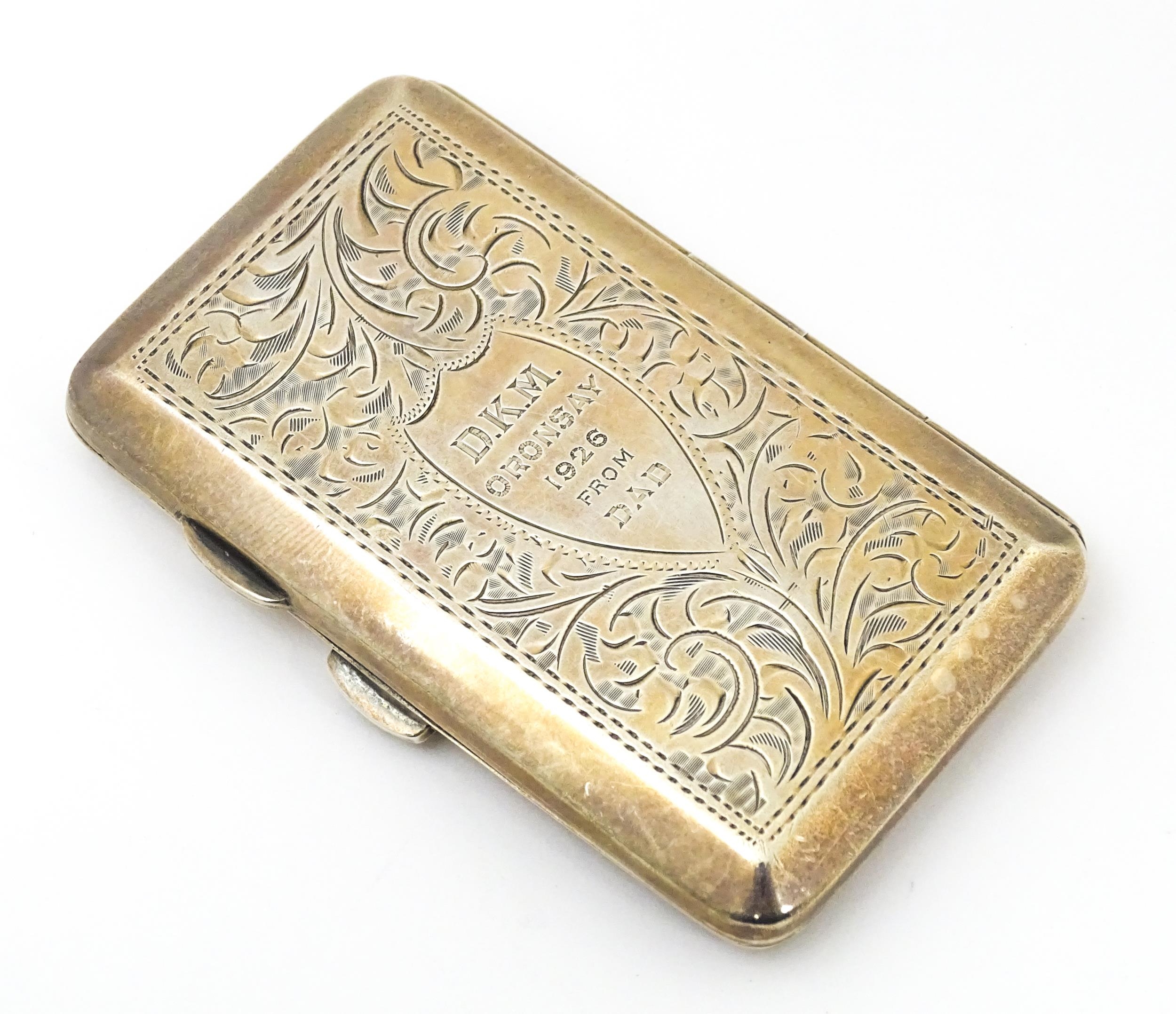 A silver cigarette case with acanthus decoration and engraved 'D. K. M. Oronsay ...', opening to