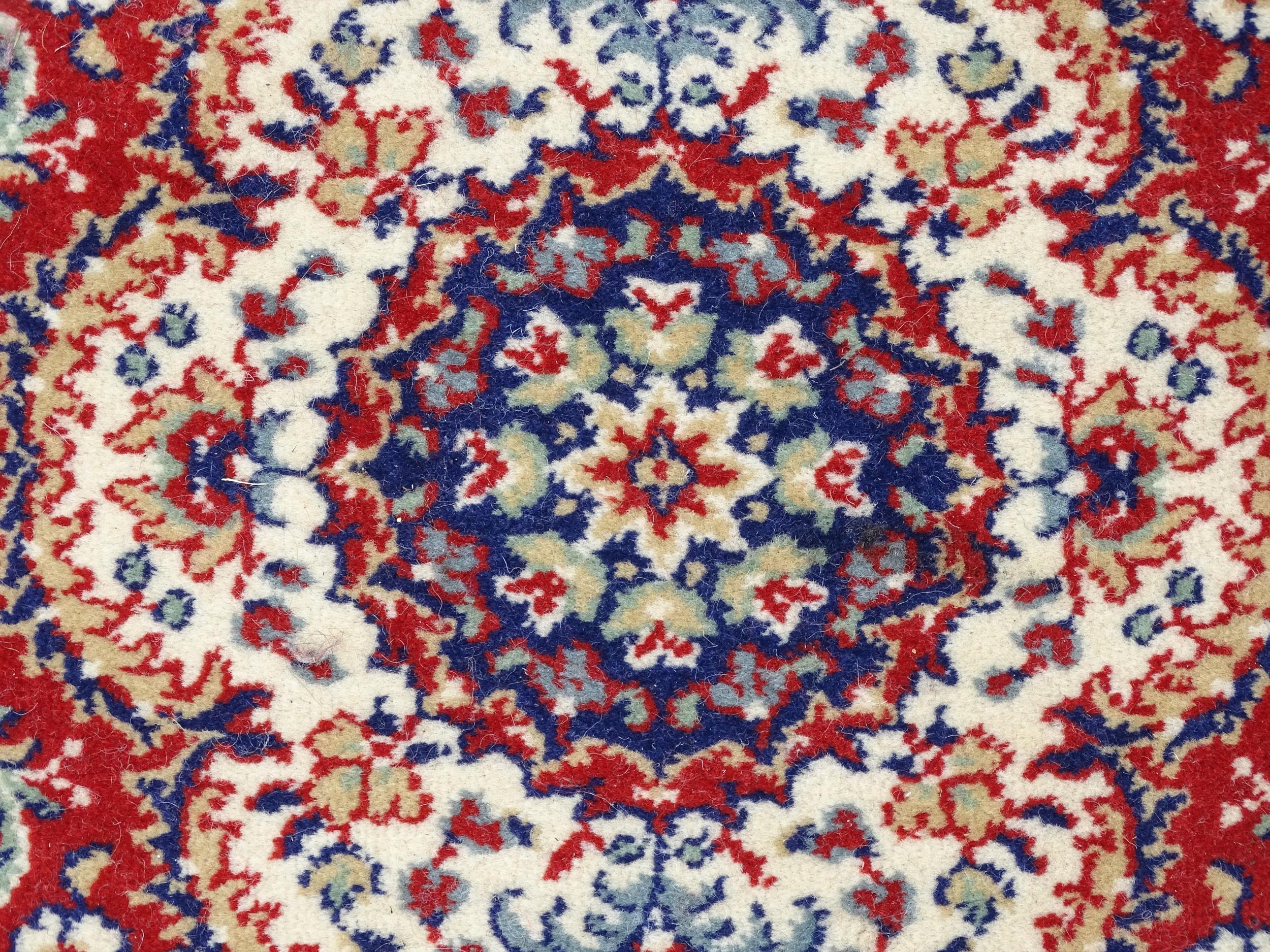 Carpet / Rug : A red ground rug with central cream and blue vignette, decorated with floral and - Image 5 of 6