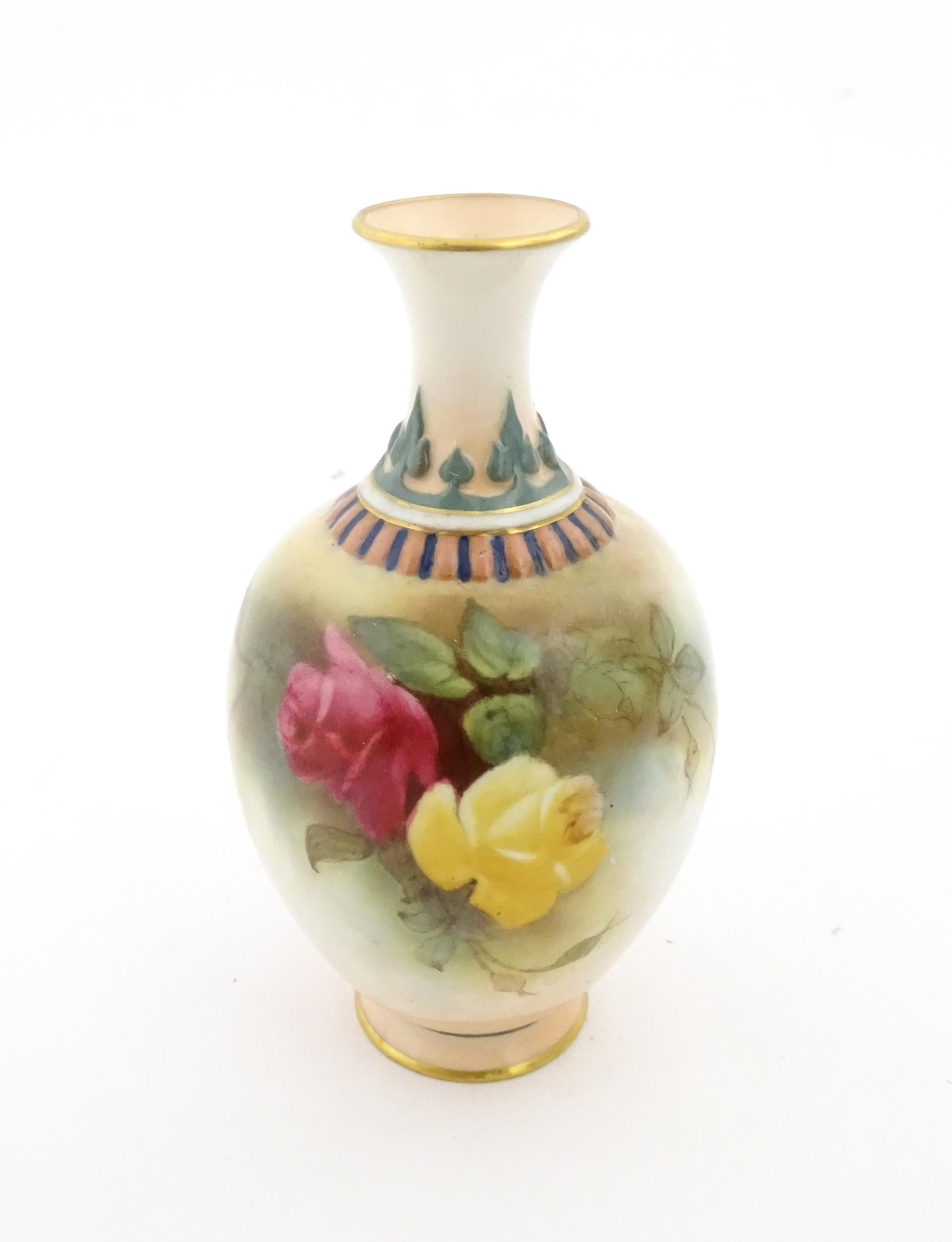 A Royal Worcester vase with hand painted decoration depicting pink and yellow roses, with gilt