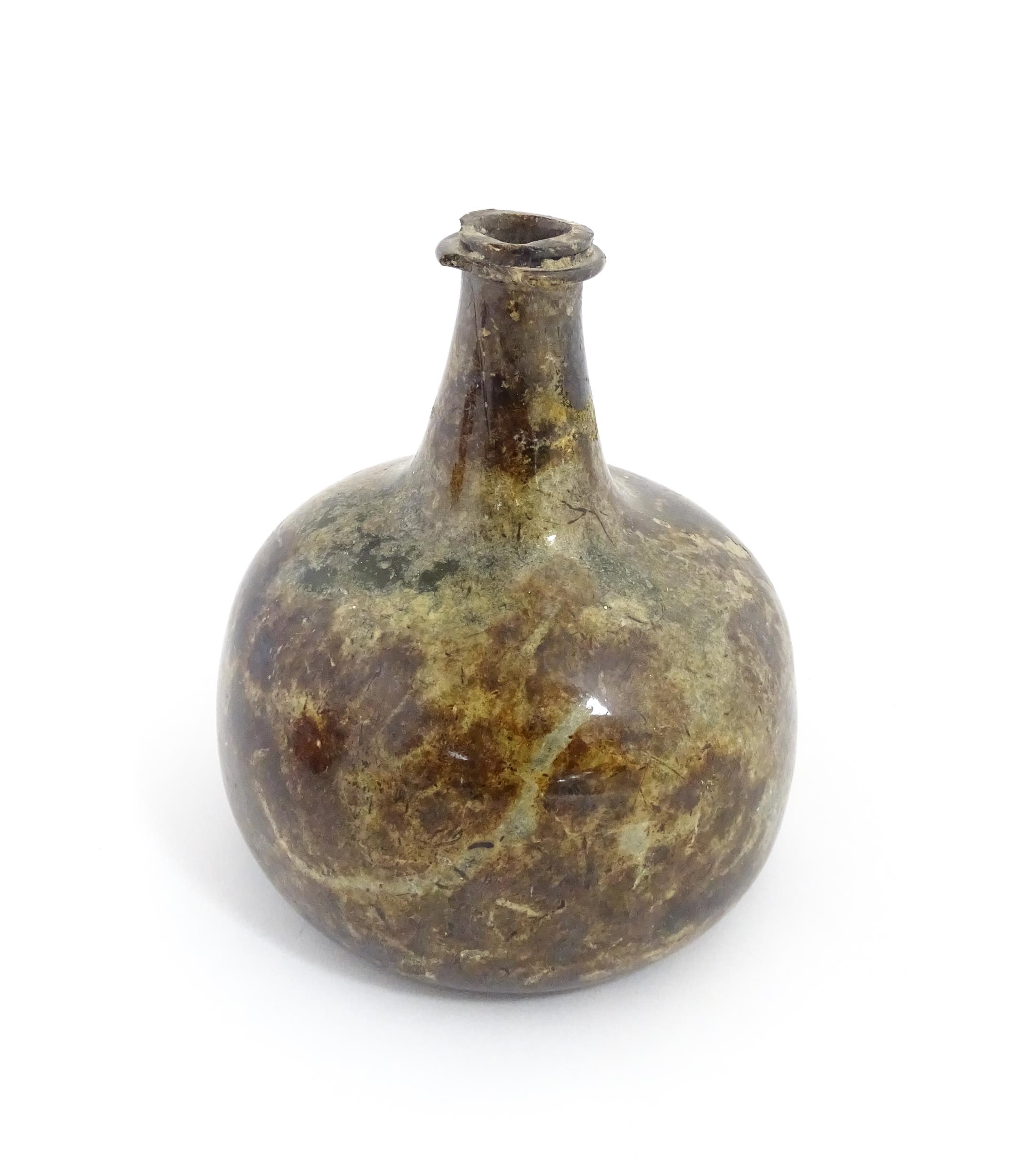 A late 18thC / early 19thC English dark olive green glass onion shape wine bottle. Approx. 6" high - Image 5 of 6