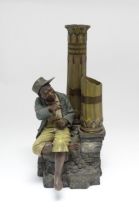 A late 19thC terracotta figure of a boy with decorative columns, having polychrome decoration, by