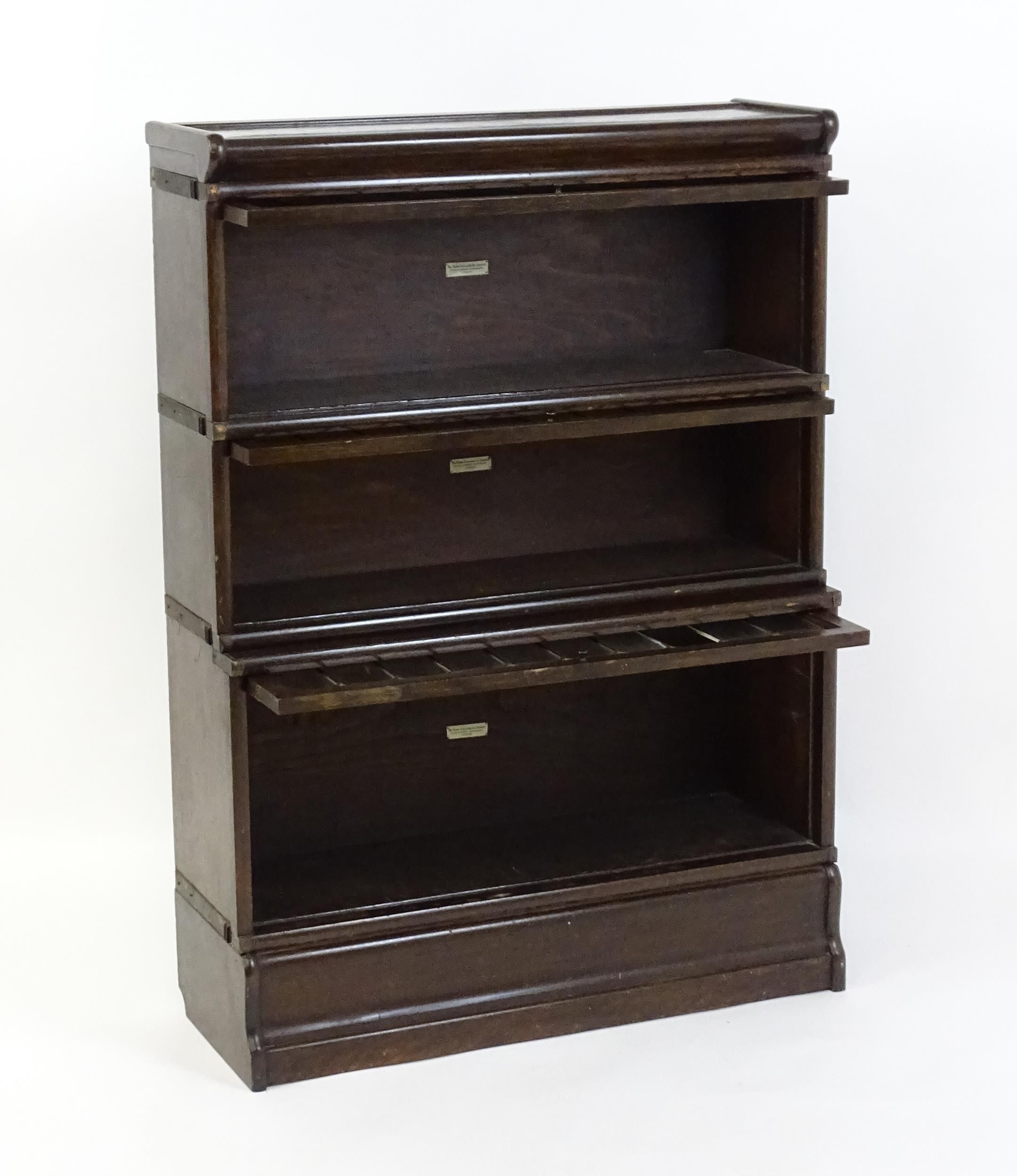 An early / mid 20thC oak Globe Wernicke bookcase with three glazed tiers above a shaped base. 34" - Image 4 of 8