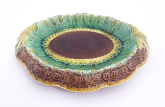 A Victorian majolica bread plate, the inner rim decorated with wheat sheaves, the outer edge bearing