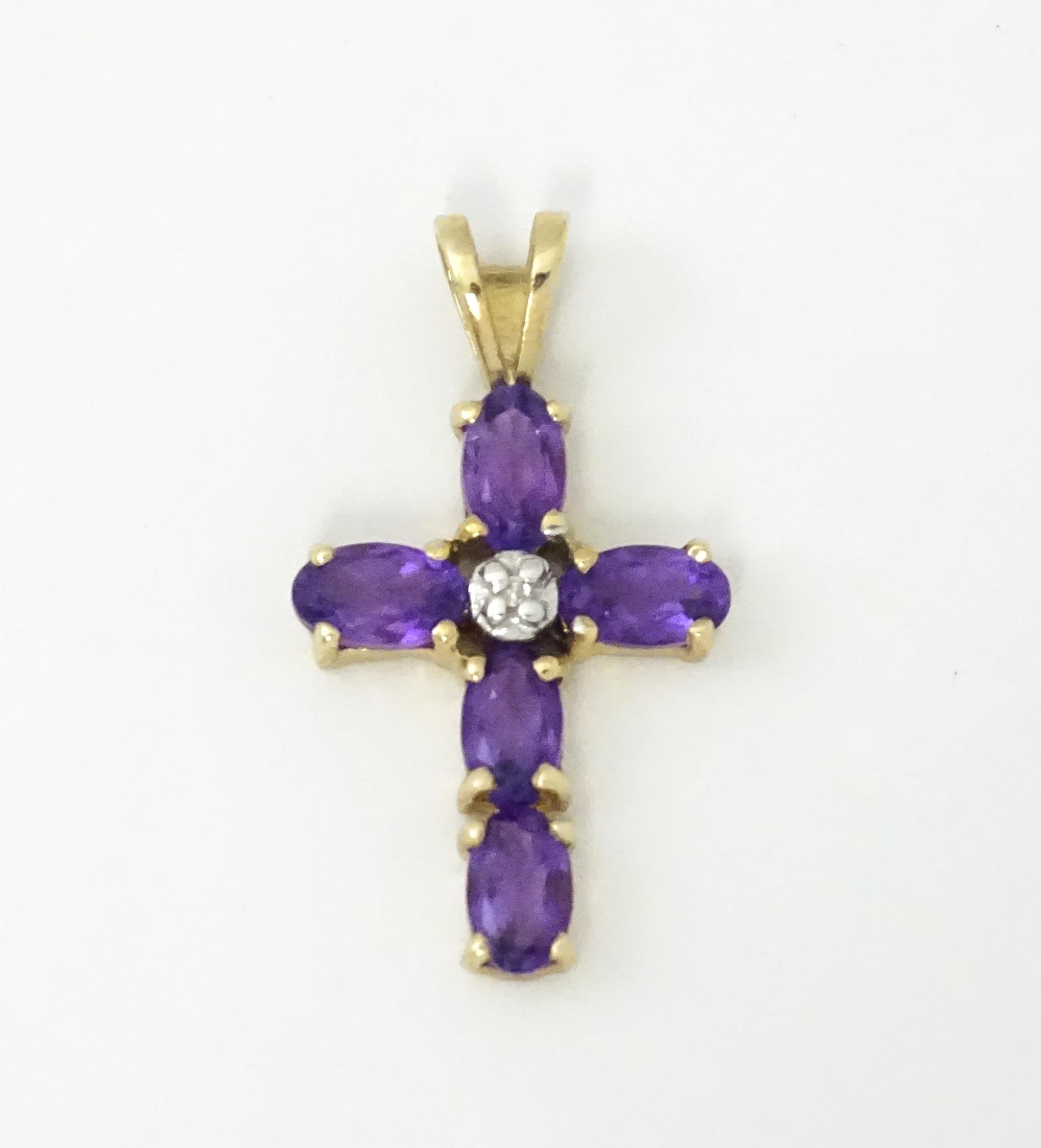 A 9ct gold cross formed pendant set with amethyst and central diamond. Approx. 1" long Please Note - - Image 2 of 6