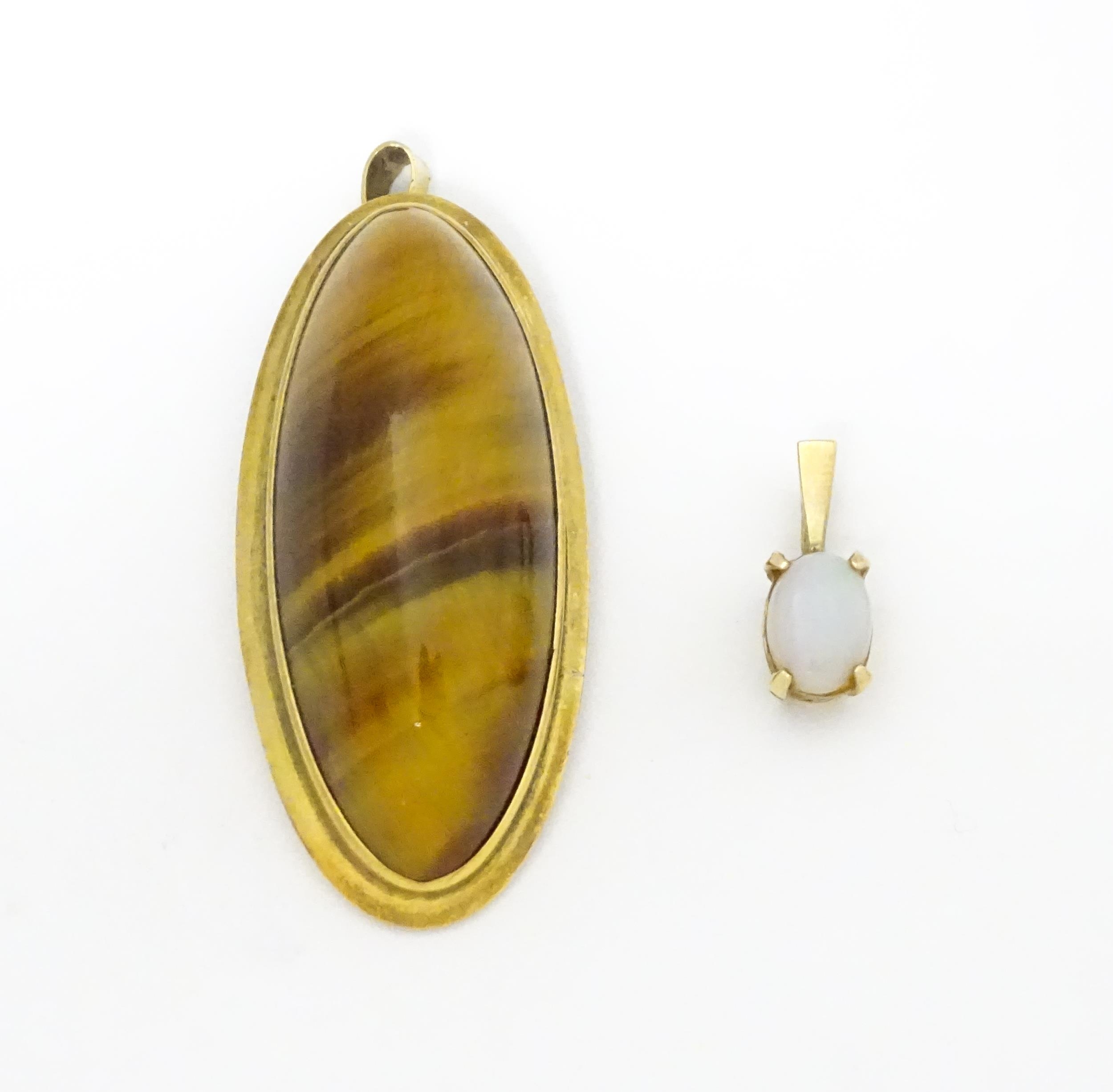 A 9ct gold pendant set with opal together with a pendant set with tigers eye cabochon. Approx 1 1/2"