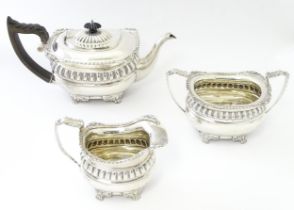 A three piece silver tea set comprising teapot, milk jug, and sugar bowl, hallmarked Chester 1904,