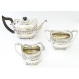 A three piece silver tea set comprising teapot, milk jug, and sugar bowl, hallmarked Chester 1904,