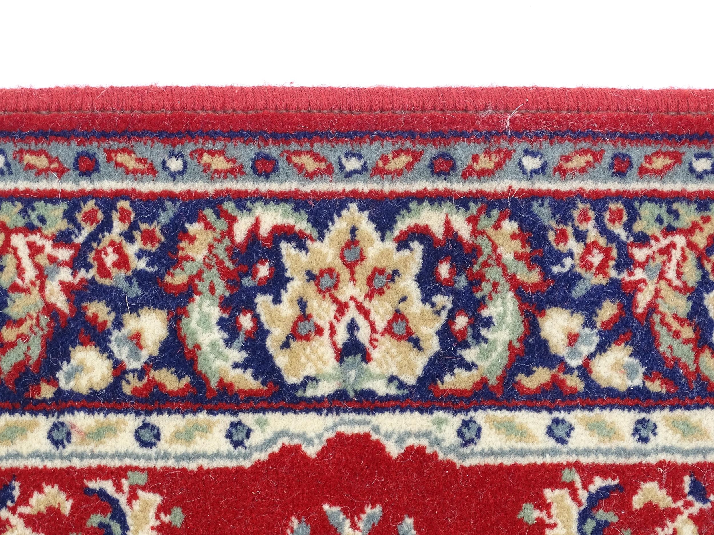Carpet / Rug : A red ground rug with central cream and blue vignette, decorated with floral and - Image 6 of 6