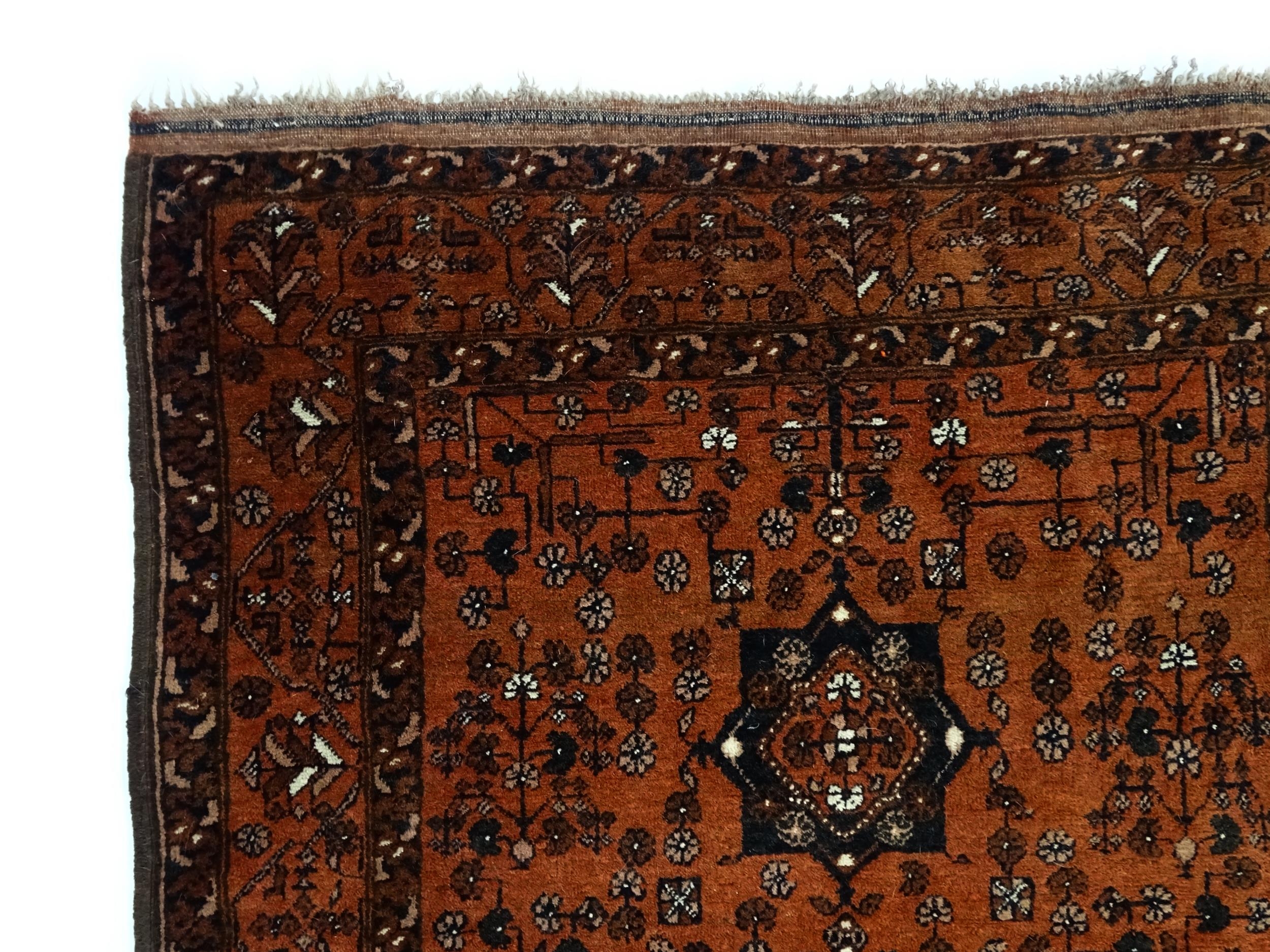 Carpet / Rug: A red ground rug decorated with floral and foliate detail, further repeated to - Image 3 of 8