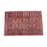 Carpet / Rug : A Pakistan wool red ground rug decorated with repeating geometric motifs with further