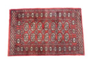 Carpet / Rug : A Pakistan wool red ground rug decorated with repeating geometric motifs with further