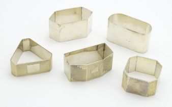 Five assorted Art Deco silver napkin rings of shaped form, hallmarks to include Birmingham 1920,