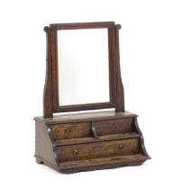 A mid 18thC oak toilet mirror with a rectangular glass above three short drawers set within a