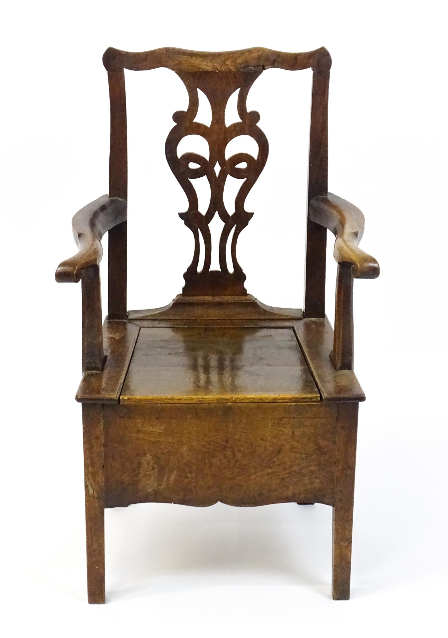 A late Georgian oak commode chair with a Chippendale style back splat above a hinged seat opening to - Image 5 of 10