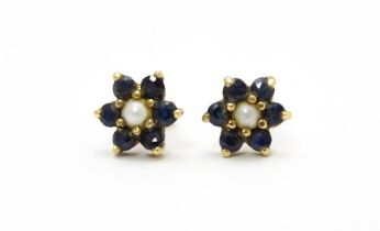 A pair of yellow metal stud earrings with flower detail set with blue stones and pearls Please