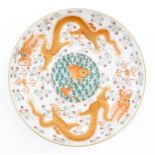 A Chinese dish decorated with central koi carp fish bordered by dragons, flaming pearls, and
