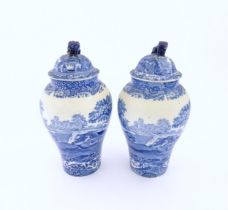 A pair of Copeland blue and white lidded vases decorated in Spode's Italian pattern depicting