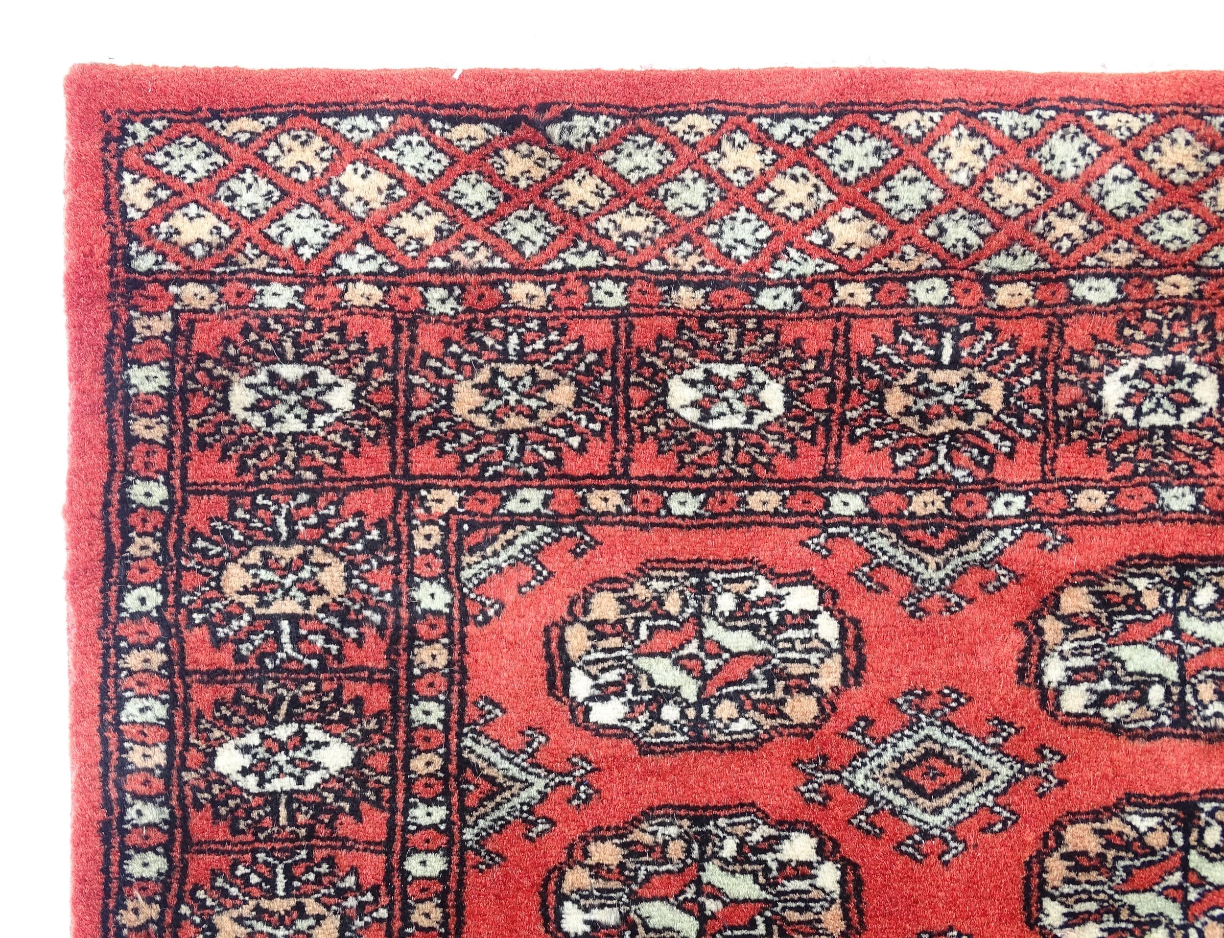 Carpet / Rug : A Pakistan wool red ground rug decorated with repeating geometric motifs with further - Image 3 of 8