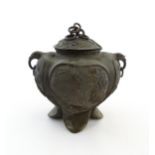 A Chinese cast vessel of lobed form with twin ring handles modelled as elephant heads, the body