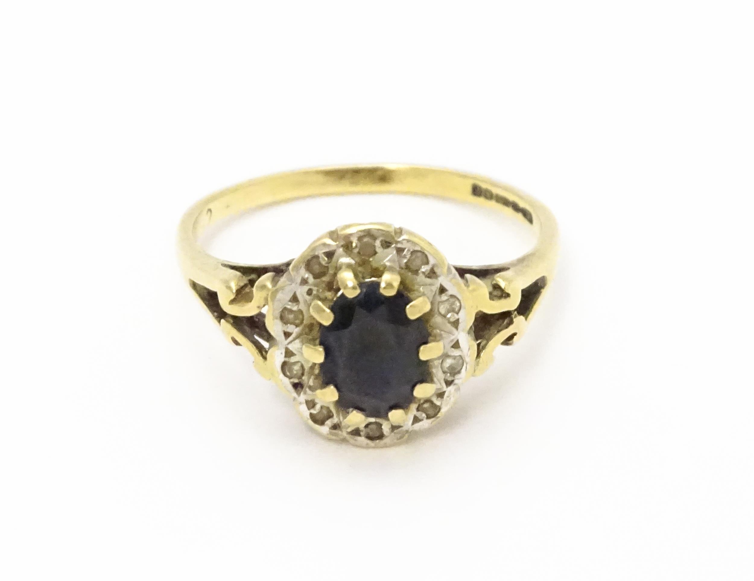 A 9ct gold ring set with central sapphire bordered by diamonds. Ring size approx. L 1/2 Please - Image 9 of 10