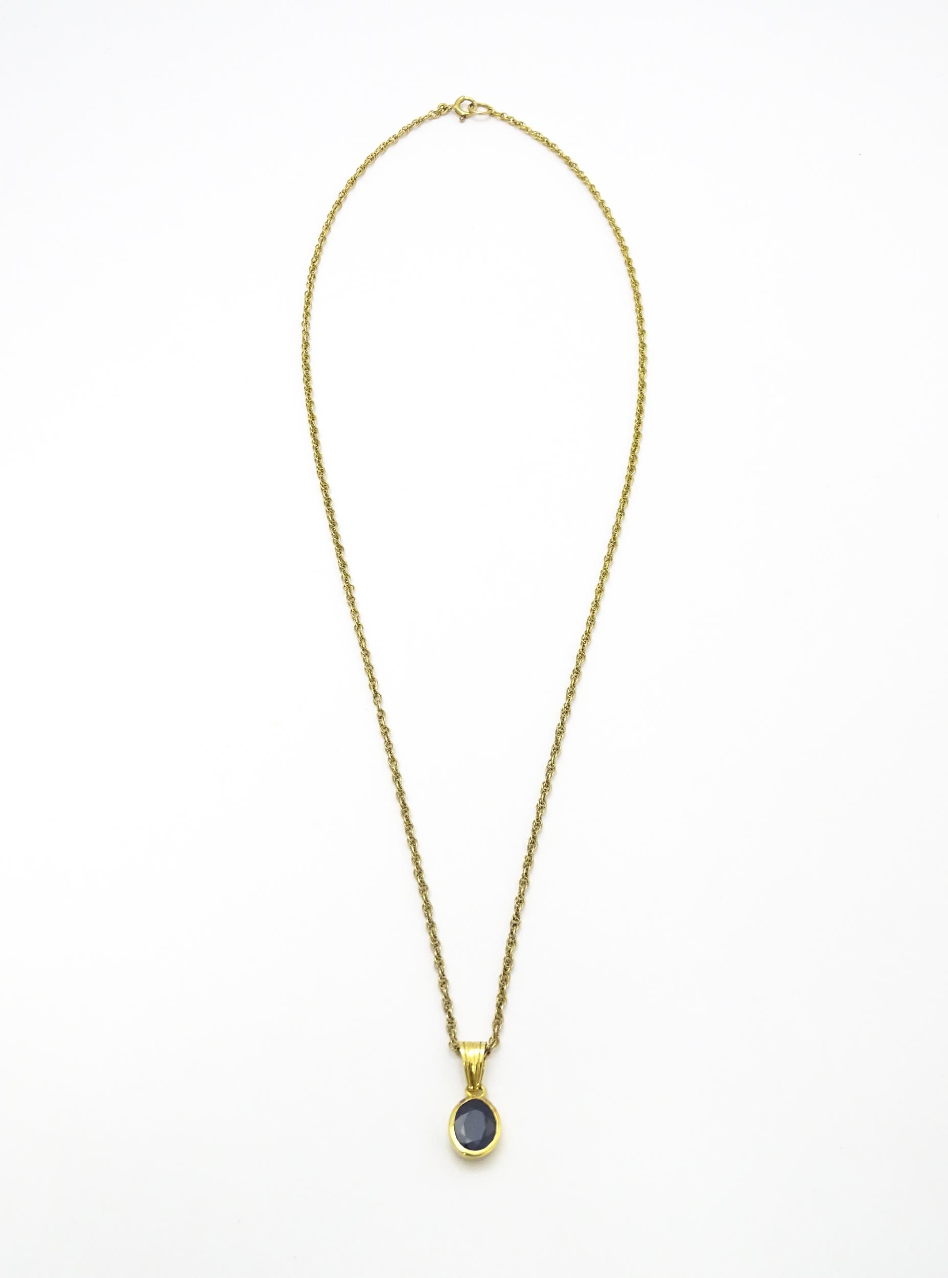 A yellow metal pendant set with central sapphire on a 9ct gold chain. Pendant approx. 1 3/4" long - Image 2 of 6