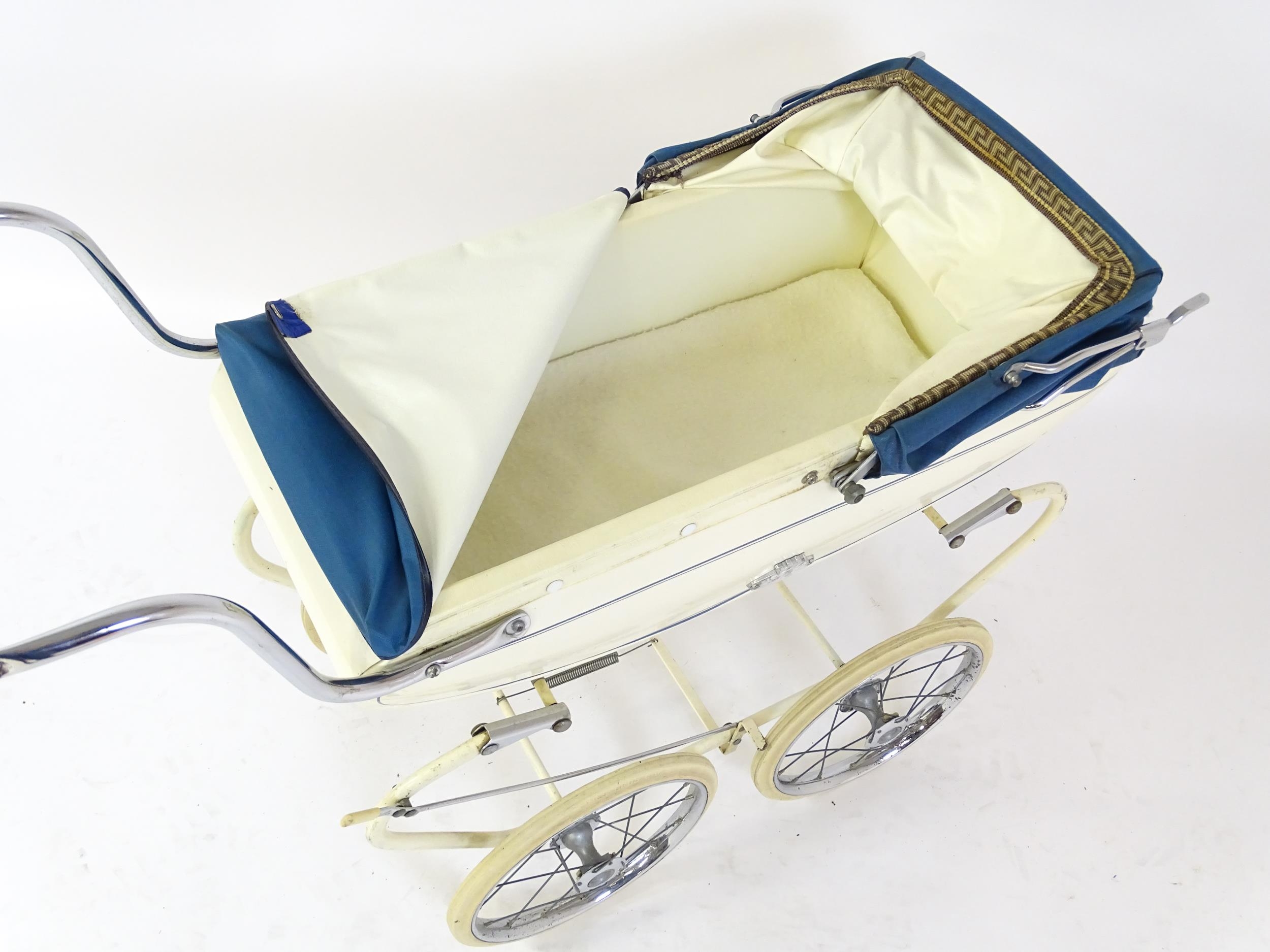 Toys: A 20thC Pedigree dolls pram with cream exterior and blue hood. Together with a plastic doll - Image 6 of 11