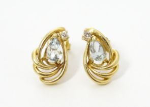 A pair of yellow metal earrings set with diamond and aquamarine. Approx. 1/2" long Please Note -